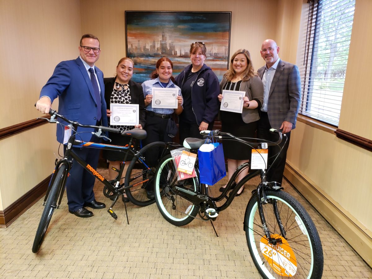 clients and attorney with bikes and certificates